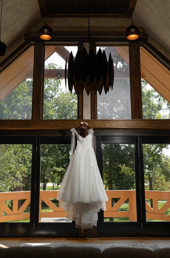 Gorgeous floral wedding gown hanging in the bridal suite at Lizton Lodge in Indiana Moody true to color.