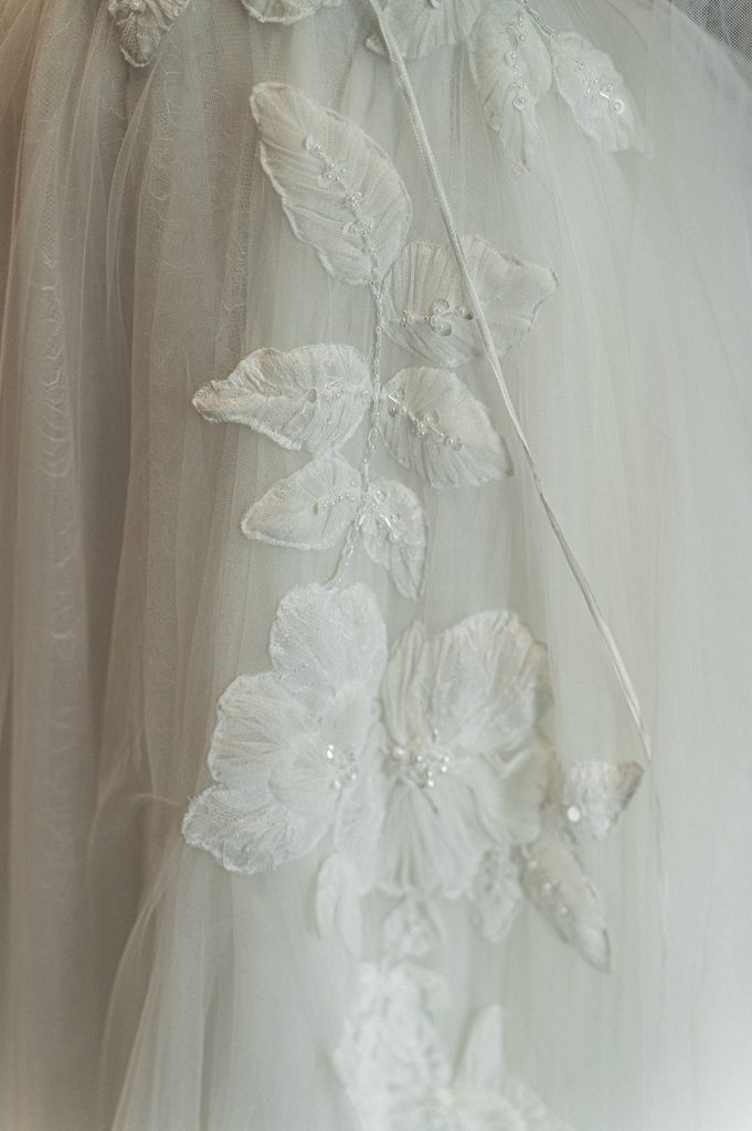 Moody true to color close up shot of a wedding bouquet and bridal dress details at Lizton Lodge.